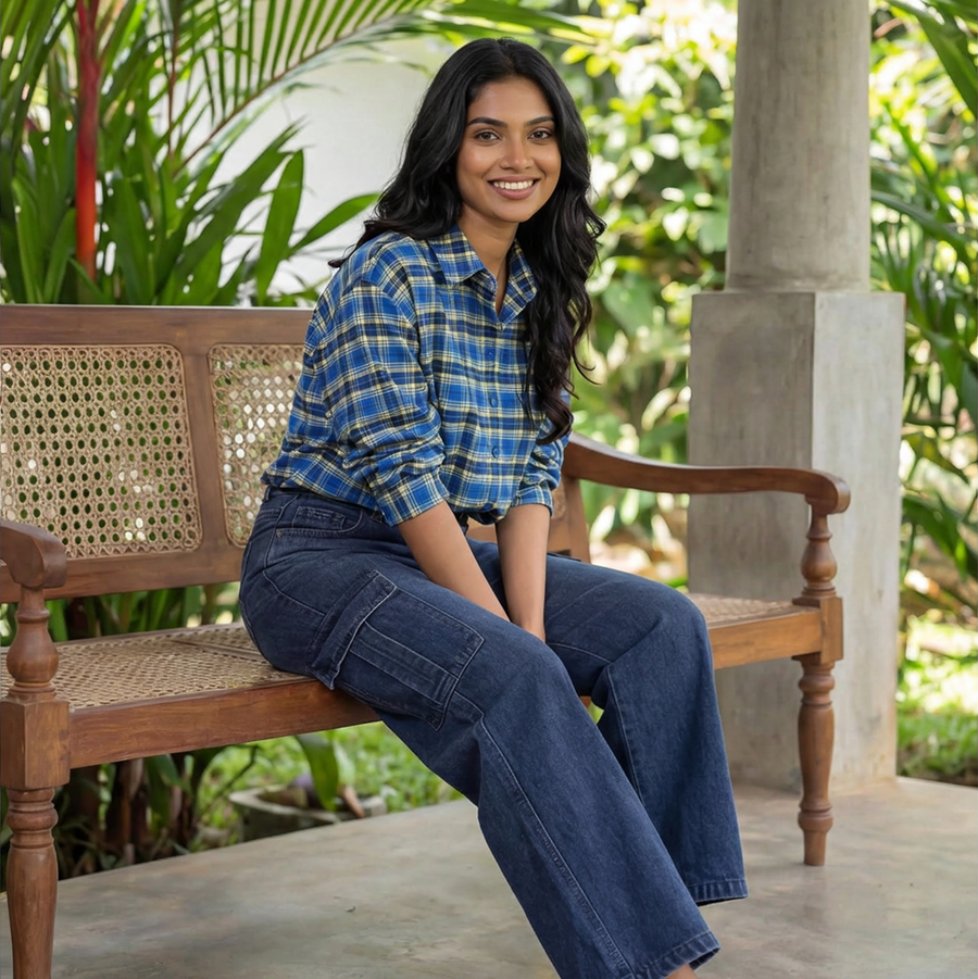 Indigo Series Woman sitting on a wooden bench outdoors with greenery in the background